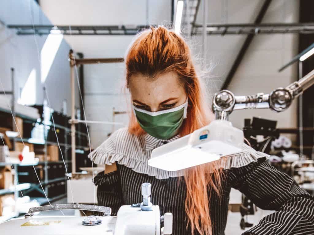 Worker in Printful facility works at an embroidery machine