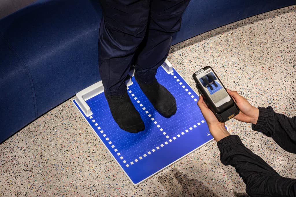 A Nike associate scans a shopper's feet using the Nike Fit app.